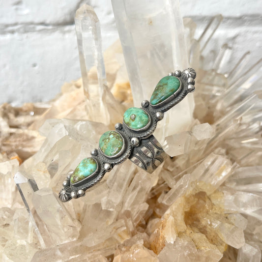 Green turquoise ring on a crystal background