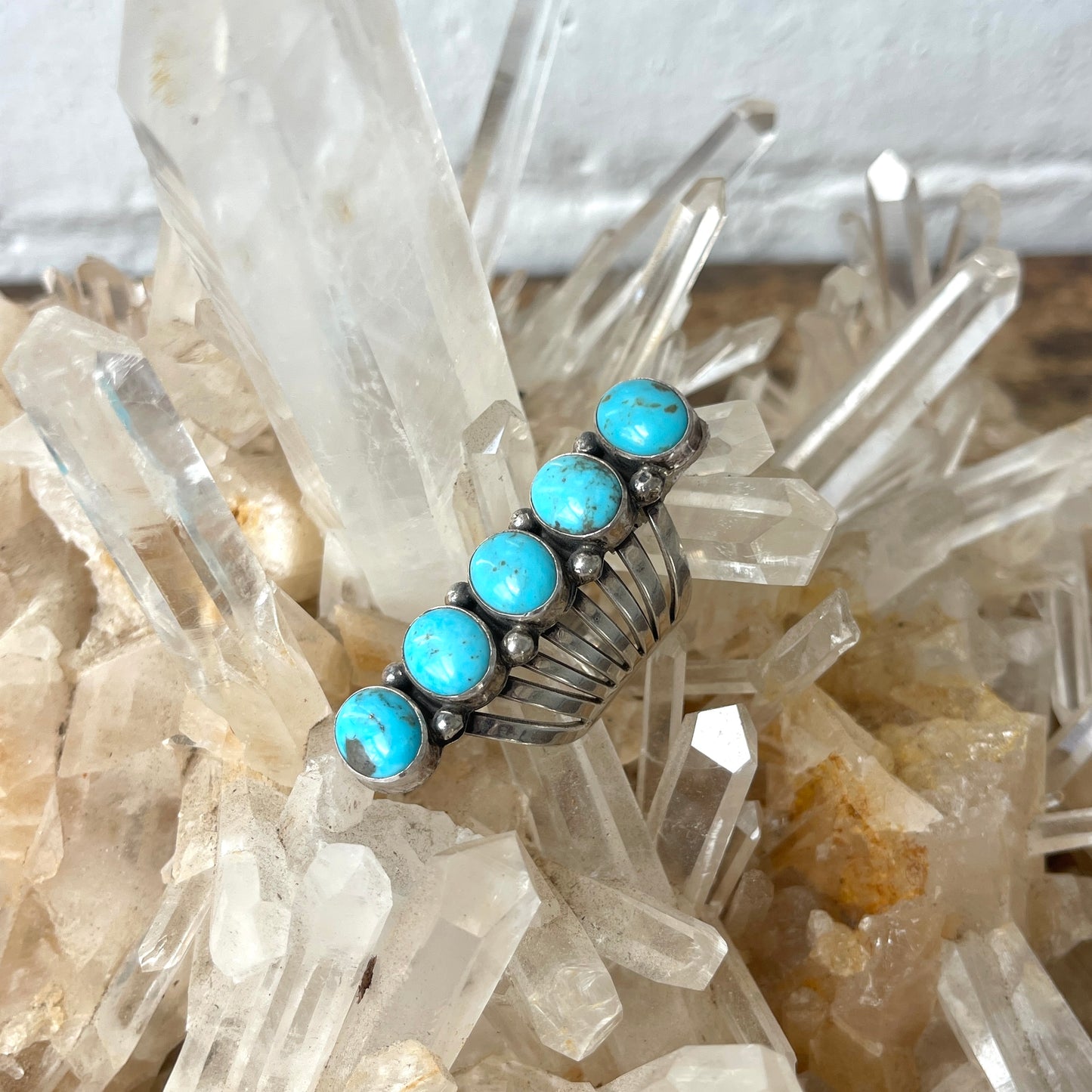 Silver ring with turquoise stones on a crystal background