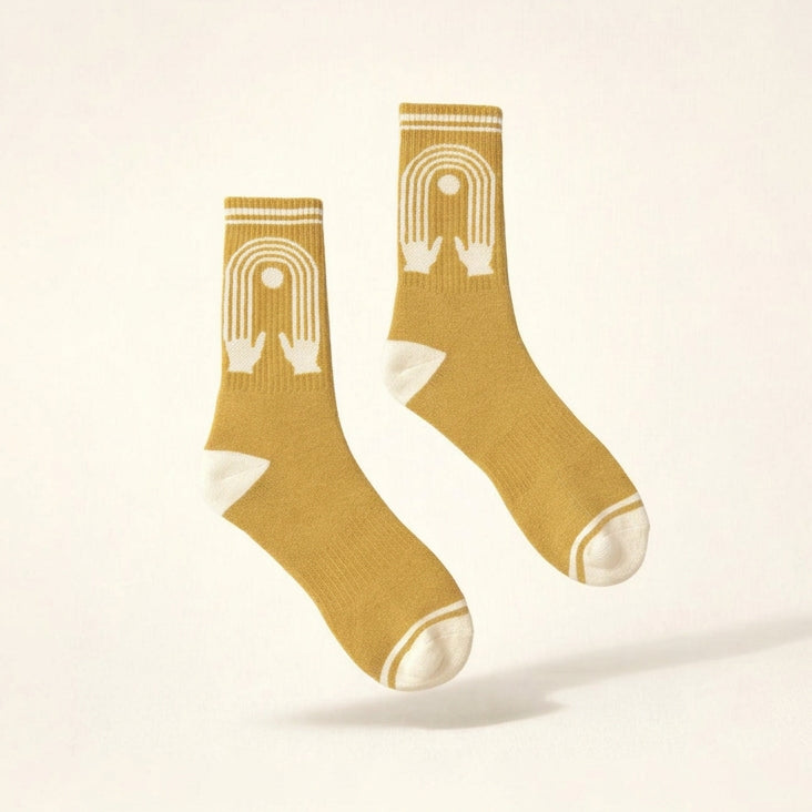a picture of Yellow Socks with a design of hands reaching into connected fingers with white toes. 