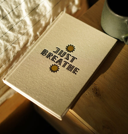 Notebook with the title 'just breathe' with sun design on a wooden surface