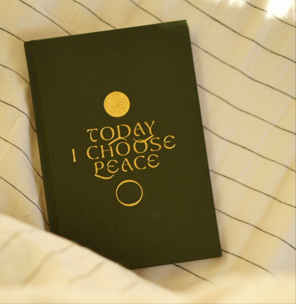 Dark green journal with 'Today I Choose Peace' text on striped fabric background