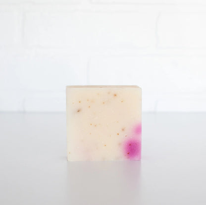 Bar of soap with pink speckles on a white background