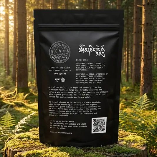 Black package of shilajit displayed on a mossy log in a forest setting.