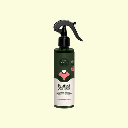 A bottle of Wild Harvest Protect Leaf Choke spray with a black trigger sprayer and a dark green and white label, centered on a pale yellow background.