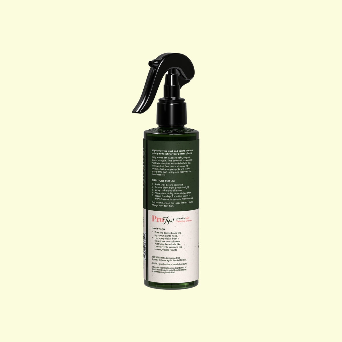 Green spray bottle with black nozzle on a beige background