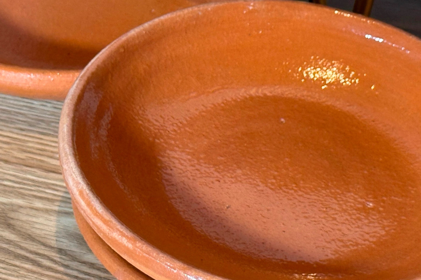 Close-up of a terracotta plate on a wooden surface
