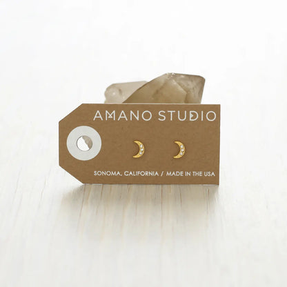 Gold moon-shaped earrings on a brown AMANO STUDIO card with 'Made in the USA' text.