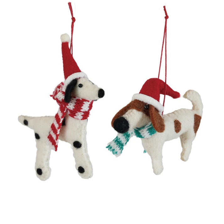 Two dog-shaped Christmas ornaments wearing Santa hats and scarves on a white background