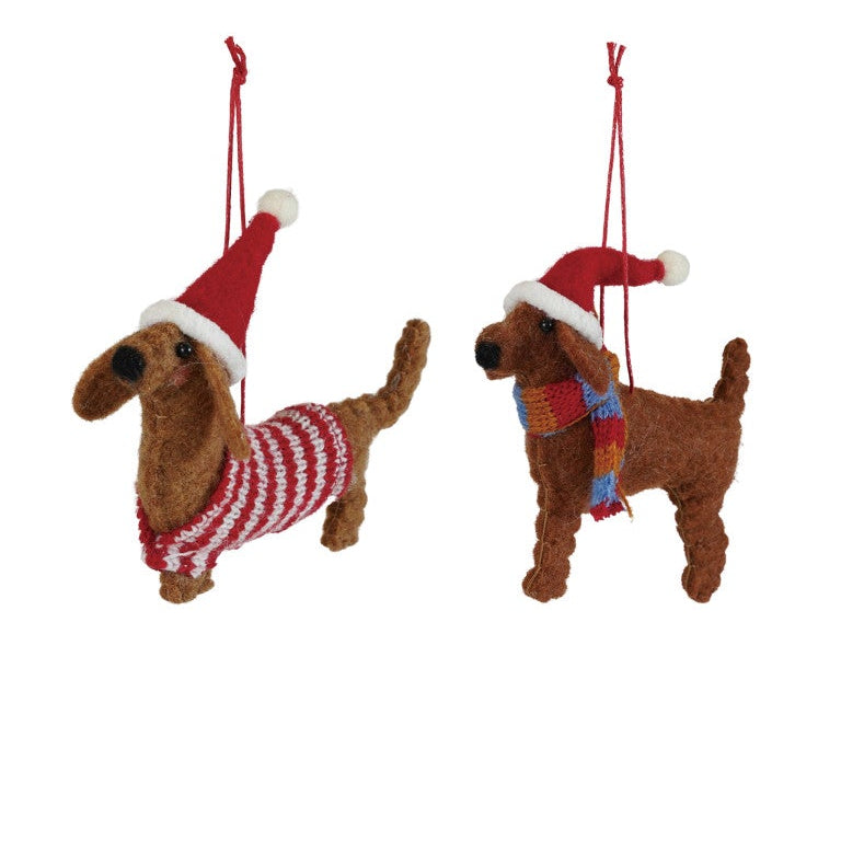 Three dog-shaped Christmas ornaments wearing Santa hats and scarves on a white background