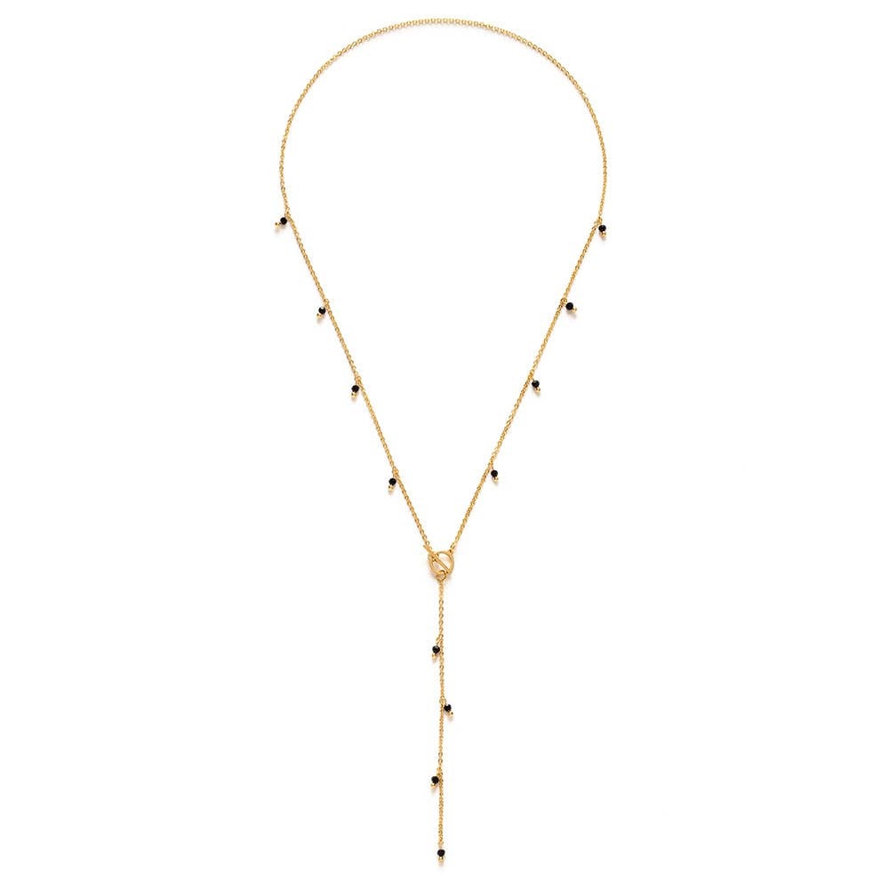 Gold necklace with black Japanese glass beads on a white background