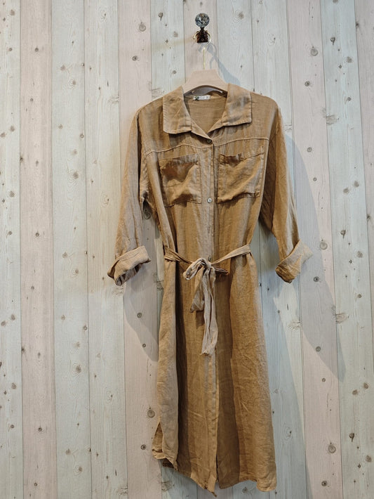 Brown shirt dress on a hanger against a wooden wall.