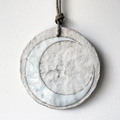 Round ceramic wall ornament with white crescent moon design