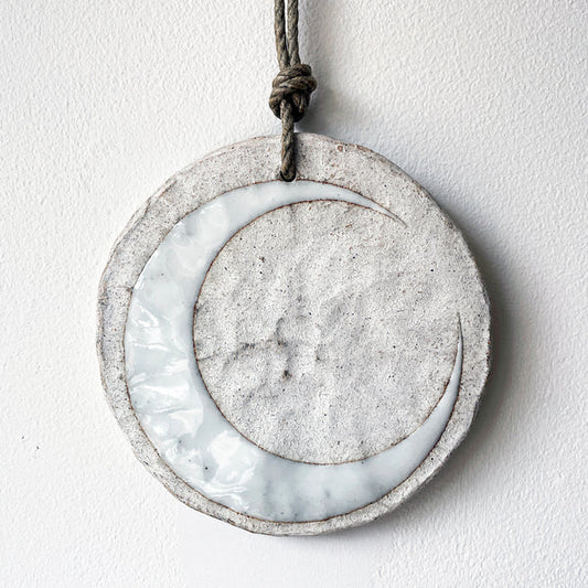 Round ceramic wall ornament with white crescent moon design