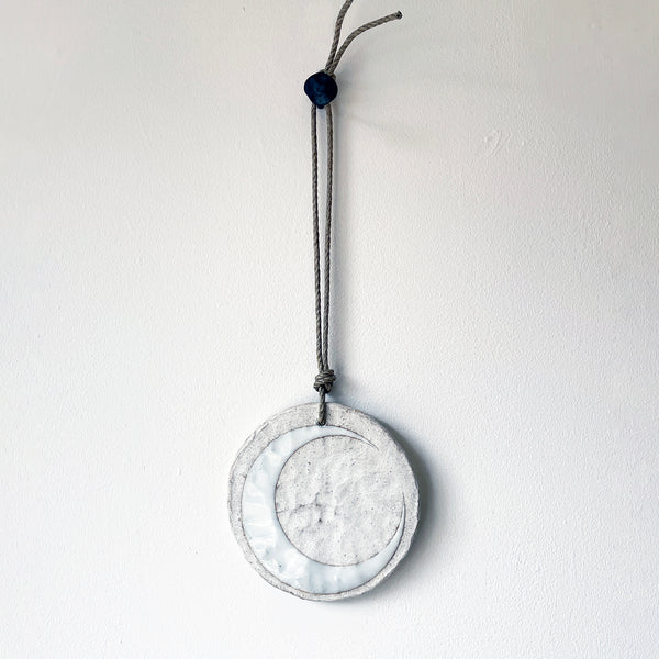 Round ceramic wall ornament with white crescent moon design
