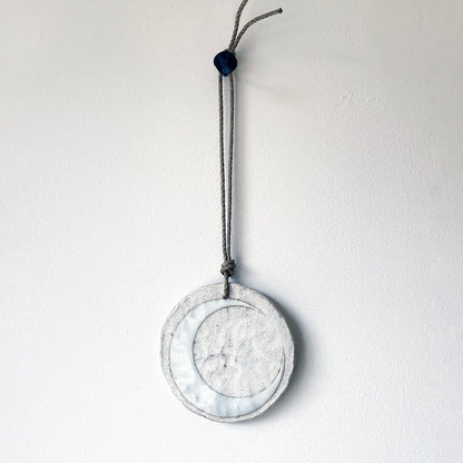 Round ceramic wall ornament with white crescent moon design