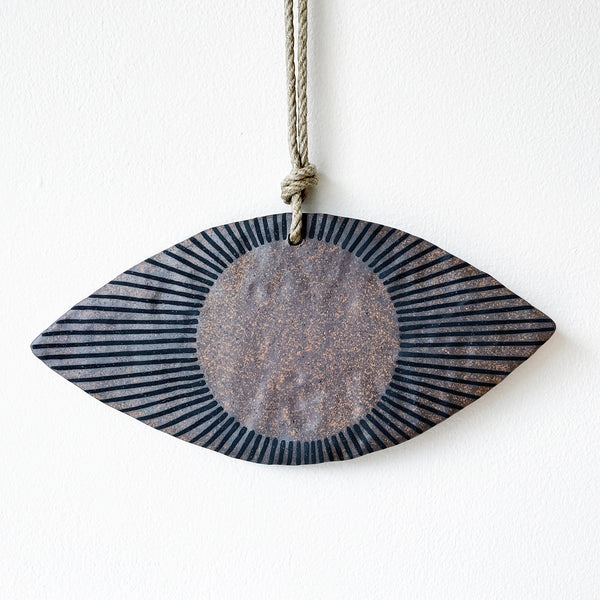 Ceramic eye shaped wall ornament with brown and black design