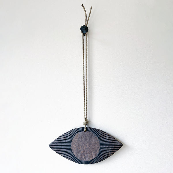 Ceramic eye shaped wall ornament with brown and black design