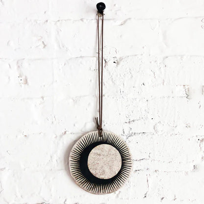 Ceramic wall hanger with black sun and crescent design