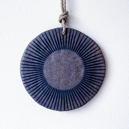 Round ceramic wall hanger with brown and black design