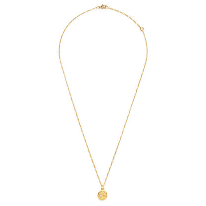 Gold necklace with a small pendant containing a small clear crystal, on a white background