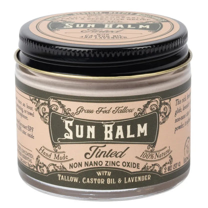 A jar of Sun Balm Tinted Grass Fed Tallow SPF 30 sunscreen balm, featuring a beige label with black text and a black lid, on a white background.