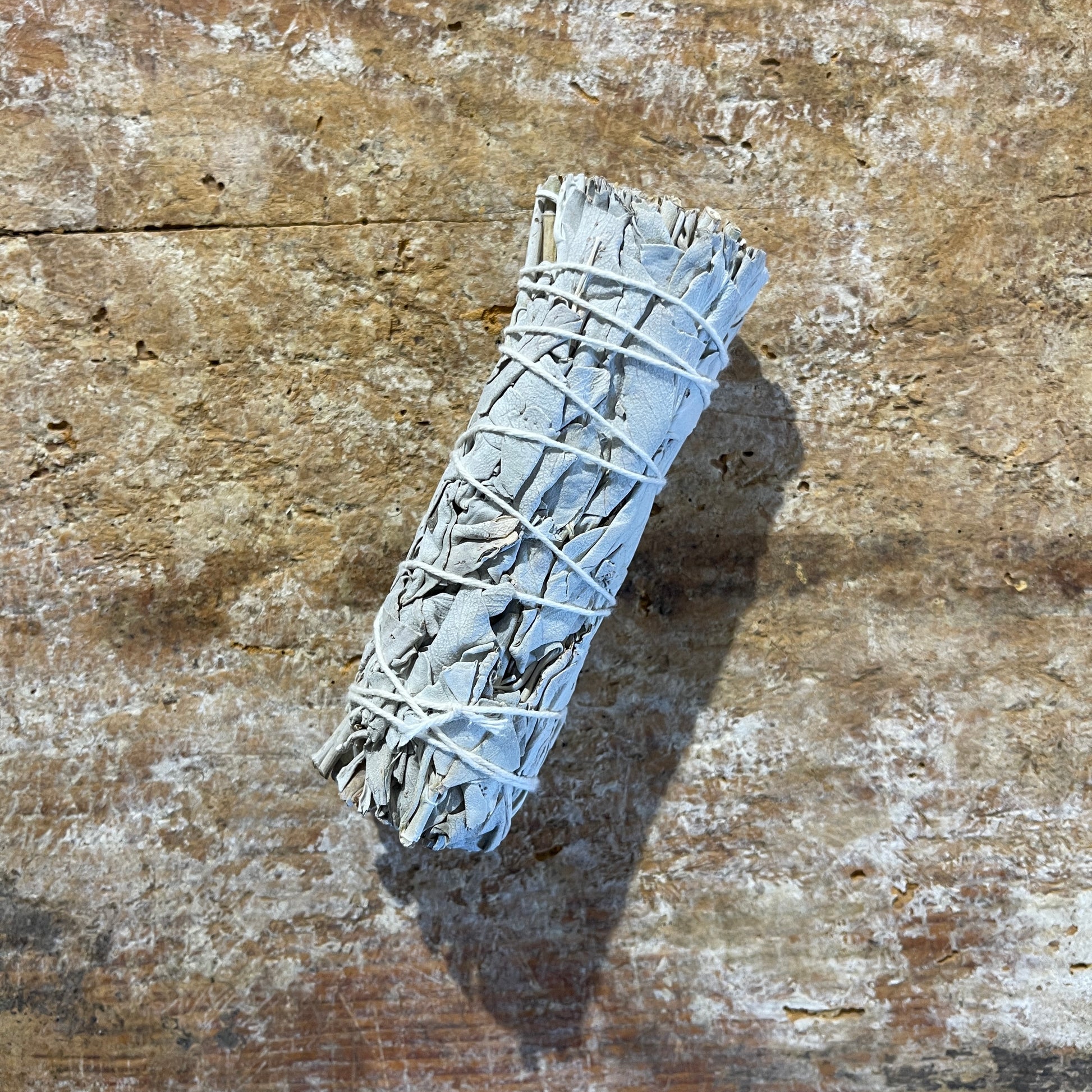 White sage bundle on a textured wooden surface