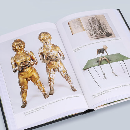 Open book with illustrations of classical statues and a diagram on a light gray background